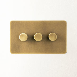 Lucian three gang dimmer switch in aged brass