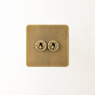 Lucian two gang intermediate toggle switch in aged brass