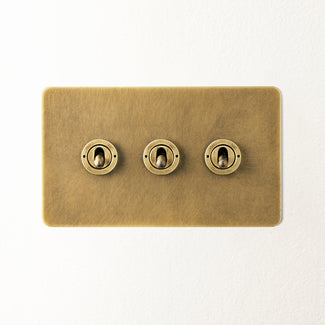 Lucian three gang 2 way toggle switch in aged brass